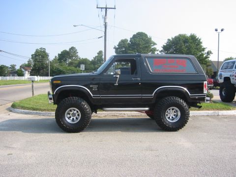 1996 Ford Bronco - This black Ford Bronco, likely from the early 1980s, is modified with large tires and a lifted suspension.