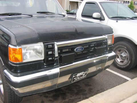 1988 Ford Bronco - Front view of a black Ford Bronco parked next to a white Ford pickup truck.