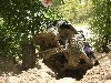 1992 Ford Bronco - An off-road vehicle navigates a muddy terrain with trees surrounding the area.