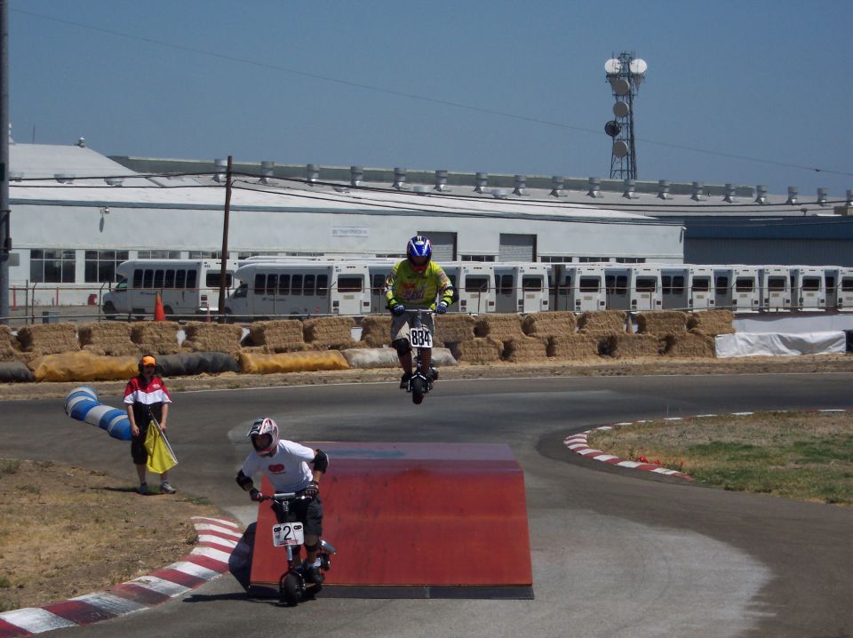 Electric scooter rider jumps over obstacle, another follows