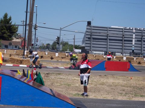 1990 Ford Bronco - Participants compete in a scooter race event with officials overseeing the action.