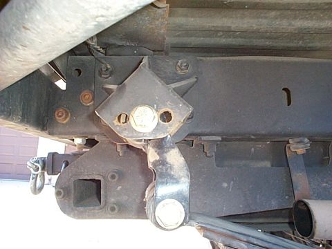 1994 Ford Bronco - Close-up view of the rear undercarriage of a vehicle, focusing on the hitch receiver and suspension parts.