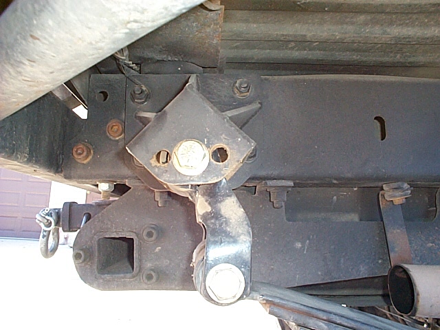 Underbody view of black frame rail with bolted bumper bracket and D-ring shackle mount