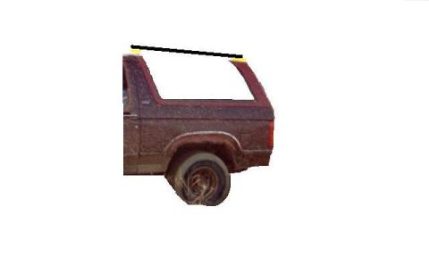 1981 Ford Bronco - A side view of a weathered Ford Bronco, showing its distinctive body style and a flat tire.