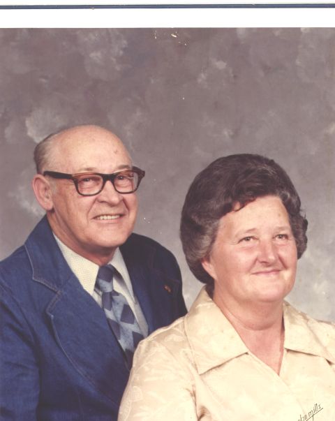 1995 Ford Bronco - A formal studio portrait captures an older couple posing together against a mottled gray backdrop.