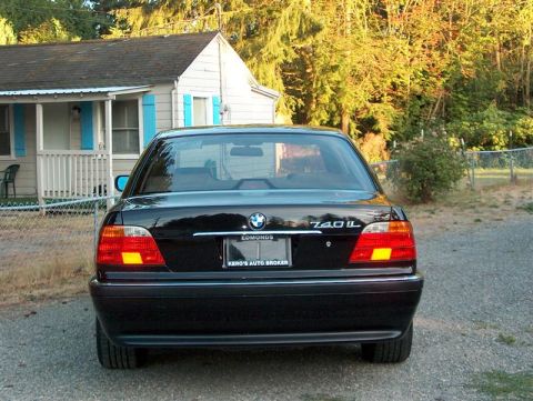 1999 BMW 7 Series - Rear view of a black 1999 BMW 740iL sedan parked in front of a house.