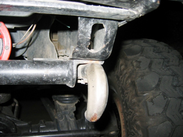 Underside view of frame bracket, rubber bump stop, and off-road tire