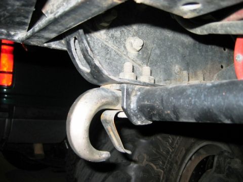 1985 Ford Bronco - Underside view of a vehicle's frame showing a tow hook and part of a tire.