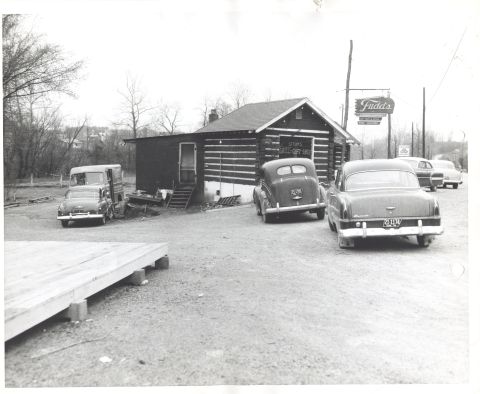 1995 Ford Bronco - Several cars are parked outside a log cabin building with a sign that reads 'Fudd's'.