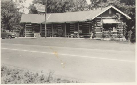 1995 Ford Bronco - A vintage roadside diner, constructed from logs, sits beside a road with a car parked out front.