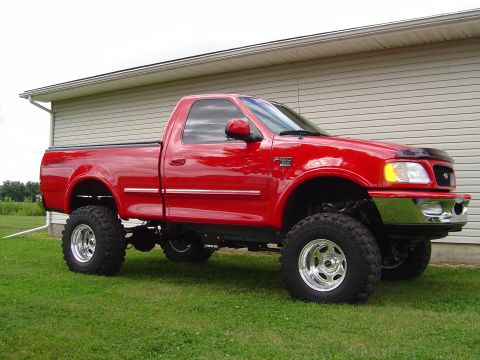 1978 Ford Bronco - This red Ford F-150 pickup truck has been lifted and features large off-road tires.