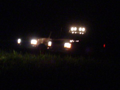 1993 Ford Bronco - A 1993 Ford Bronco is visible at night, its headlights and roof lights illuminated.
