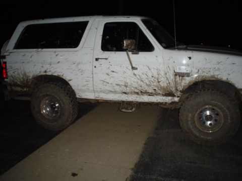 1993 Ford Bronco - Mud-covered SUV with a boxy body style and off-road tires is seen from the side.