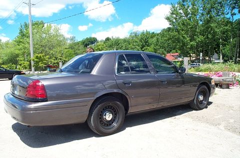 2001 Ford Crown Victoria - Gray 2001 Ford Crown Victoria sedan seen from the rear quarter angle on a sunny day.