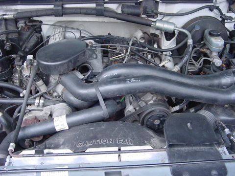 1989 Ford Bronco - Close-up view of the engine compartment, showing various mechanical components and hoses.