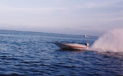 1994 Ford Bronco - A speed boat cuts through the water, leaving a wake behind it as another boat is visible in the distance.