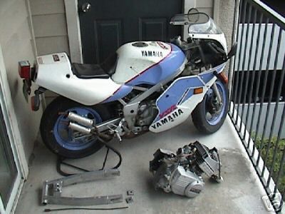 1994 Ford Bronco - A disassembled white and blue Yamaha motorcycle sits on a stand with its engine nearby.