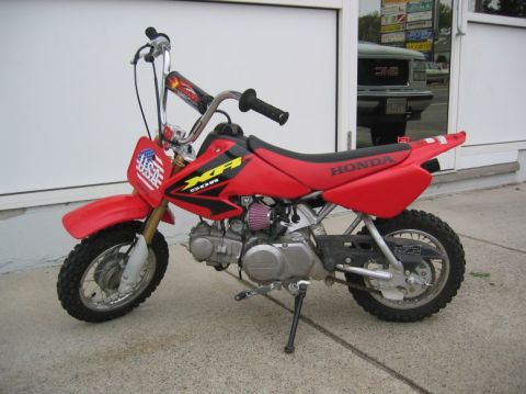 1994 Ford Bronco - This red Honda XR dirt bike is parked outside a building.
