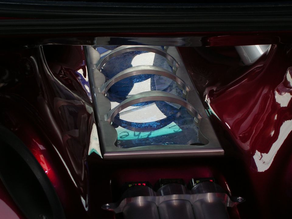 Custom car interior with a metal bracket holding three circular blue items. Text is visible on one of the blue items