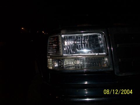 1994 Ford Bronco - The front headlight assembly of a 1994 Ford Bronco is visible, chrome trim and an amber turn signal.
