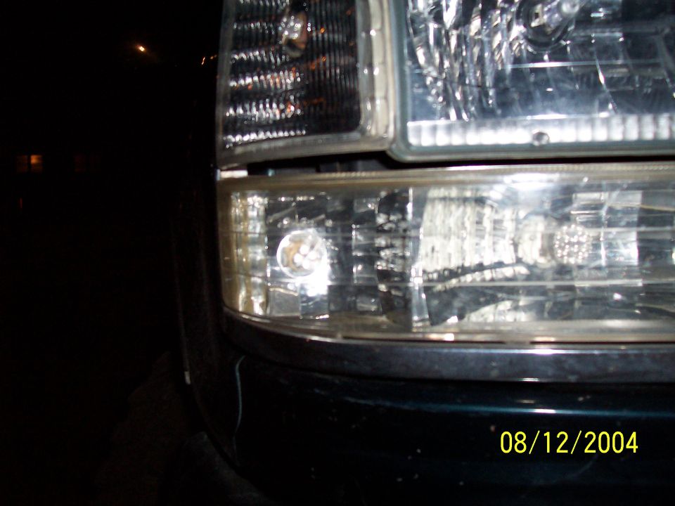 Close-up of a vehicle's headlight assembly. Date stamp reads 08/12/2004