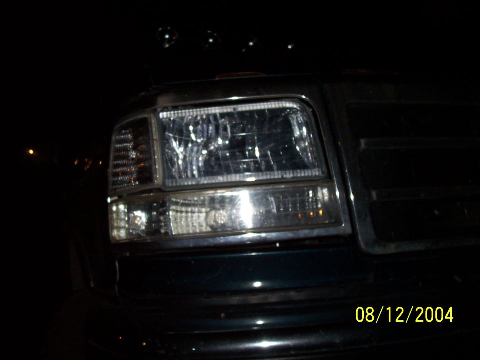 Aftermarket clear headlight and corner lamp on a dark truck at night