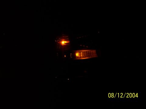 1994 Ford Bronco - Front view of a 1994 Ford Bronco's headlight and turn signal assembly at night.