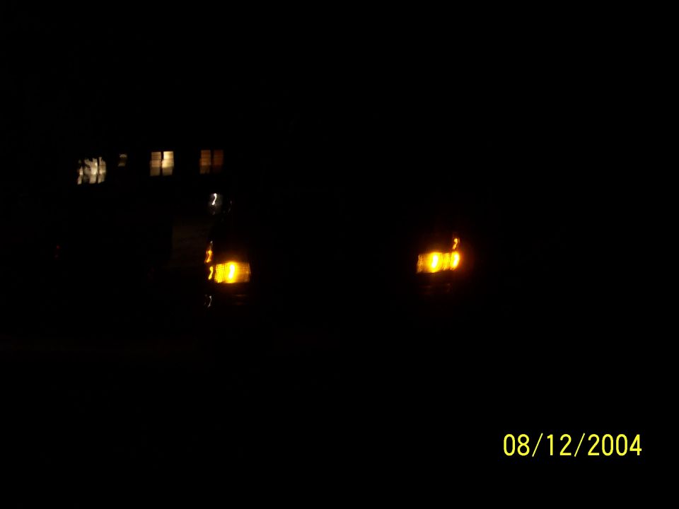 Truck front at night with only the amber parking lamps glowing in the dark