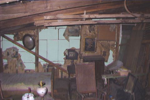 1995 Ford Bronco - The interior of a room shows significant disrepair with damaged walls and scattered furnishings.