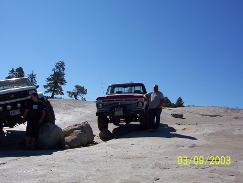 1976 Ford F-100 - Two trucks are parked on a rocky terrain under a clear blue sky.