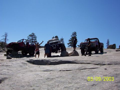 1976 Ford F-100 - Several off-road vehicles and people are gathered on a rocky landscape on a sunny day.