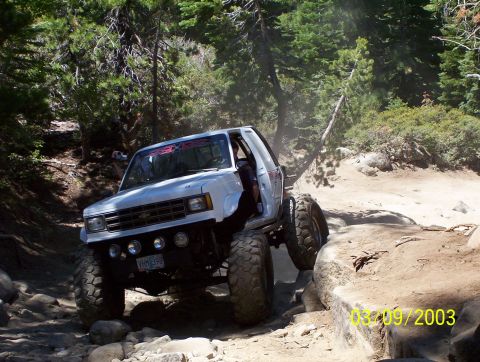 1976 Ford F-100 - Modified pickup truck with large tires navigating a rocky off-road trail.