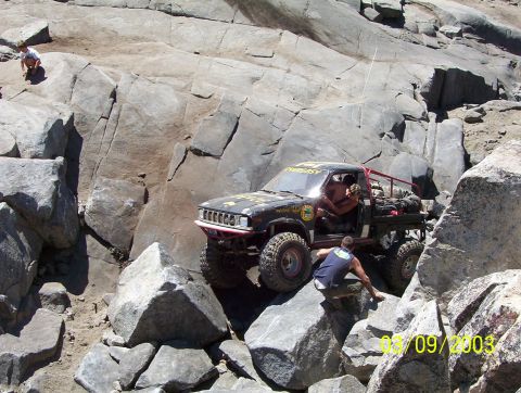 1976 Ford F-100 - Off-road truck navigating difficult rocky terrain during an event.
