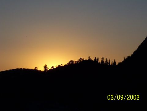 1976 Ford F-100 - A scenic sunset over a mountain range, captured on March 9, 2003, with Supermotors.net branding visible.
