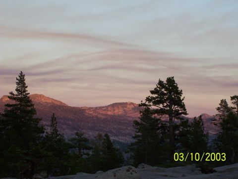 1976 Ford F-100 - A scenic view of mountains and trees during a colorful sunset, with a date watermark.