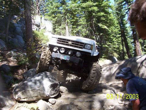 1976 Ford F-100 - Off-road truck navigates a rocky trail with steep inclines and large boulders.