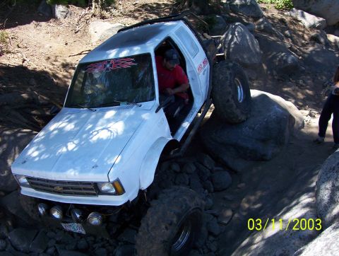 1976 Ford F-100 - Off-road vehicle with large tires navigating a rocky terrain.