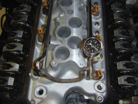 1993 Ford Bronco - Overhead view down into a V8 engine bay with both valve covers removed, showing rows of roller rocker arms and valve springs on either side…