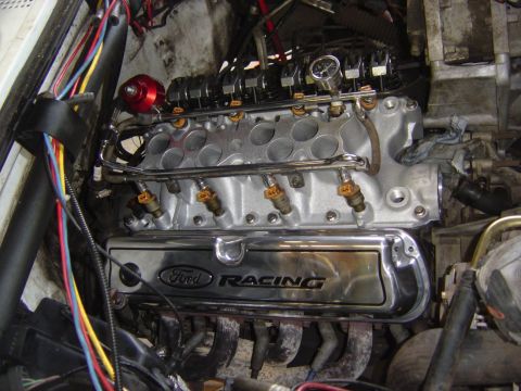 1993 Ford Bronco - In-vehicle view of a small-block Ford V8 mid-build with the upper intake off, showing the silver lower intake manifold, chrome fuel rails w…