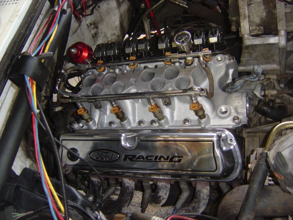 Ford V8 with lower intake exposed, chrome fuel rails, red fuel pressure regulator, Ford Racing valve cover