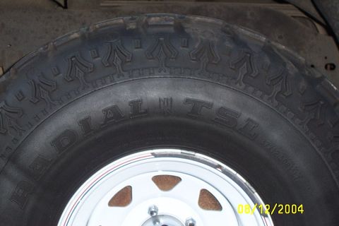 1996 Ford Bronco - A close-up view of a vehicle's tire and wheel assembly, showing tread detail and markings.