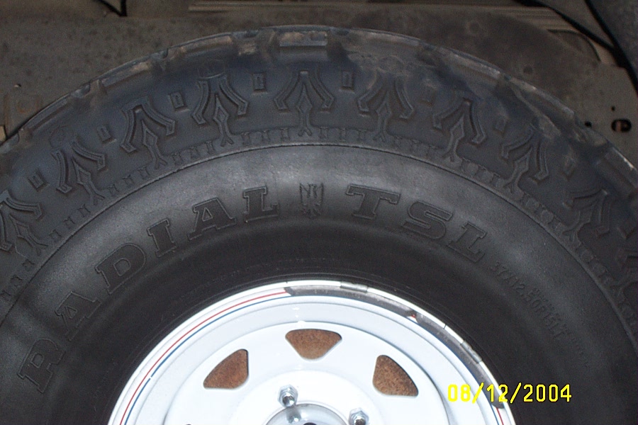 Super Swamper Radial TSL mud tire on a white steel spoke wheel, sidewall close-up