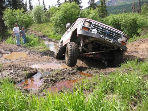 1985 Ford Bronco - This 1985 Ford Bronco is navigating a challenging muddy off-road path.