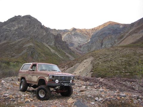 1985 Ford Bronco - Modified Ford Bronco navigates a , rocky mountain landscape.