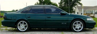 2000 Honda Accord - Side view of a green sedan with custom rims, parked outdoors near a residential building.