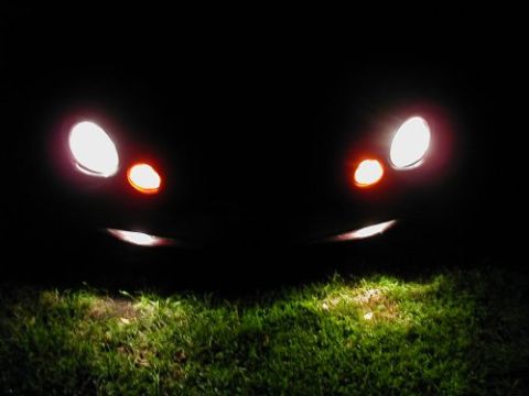 1997 Ford Taurus - Headlights and turn signals glow in the dark, illuminating the grass below.