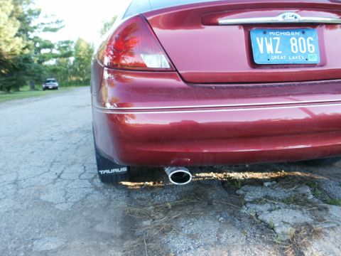 2000 Ford Taurus - The rear of a red 2000 Ford Taurus is visible, with a Michigan license plate and exhaust pipe.