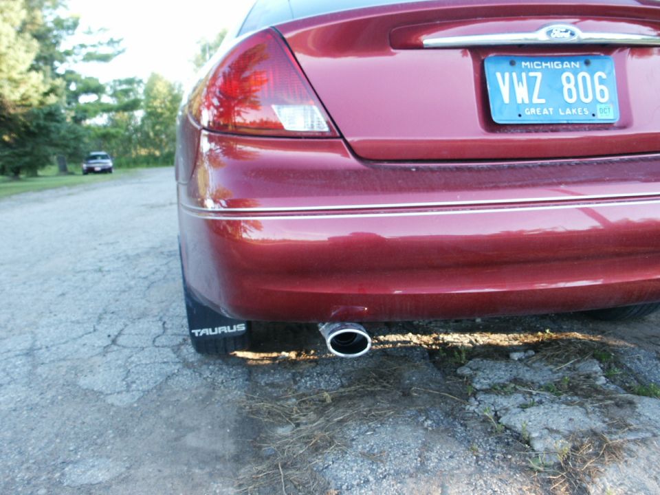Red 2000 Ford Taurus rear bumper with license plate VWZ 806 and exhaust pipe