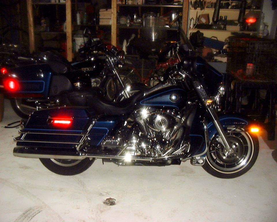 Dark blue Harley-Davidson touring motorcycle with chrome V-twin parked in a shop