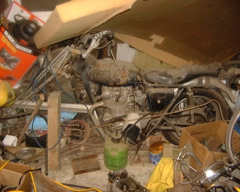 1985 Ford F-150 - This motorcycle appears to be in a state of disrepair, surrounded by various items in a storage space.